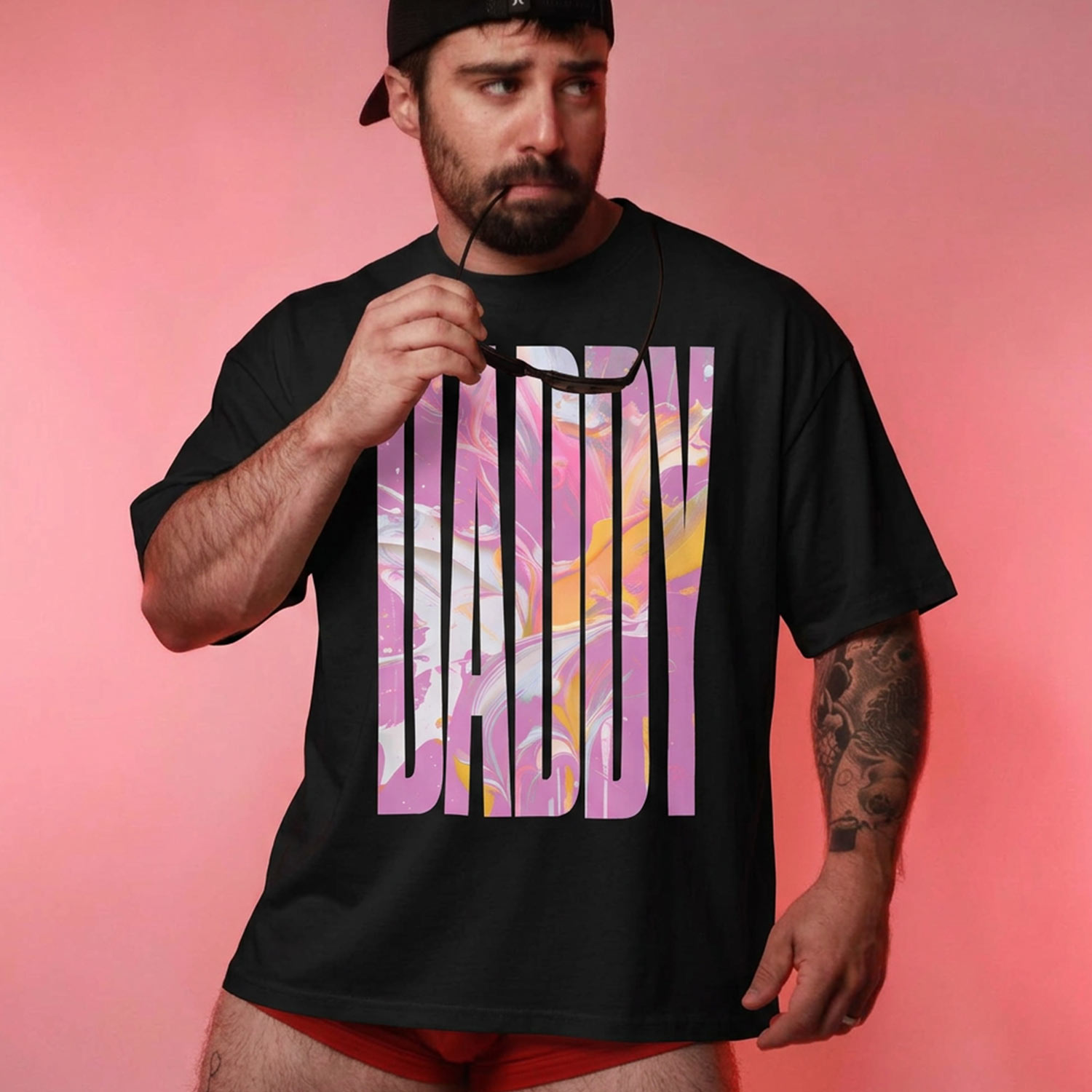 Model in black Gayer Things Daddy oversized organic T-shirt — marble DADDY graphic, lifestyle
