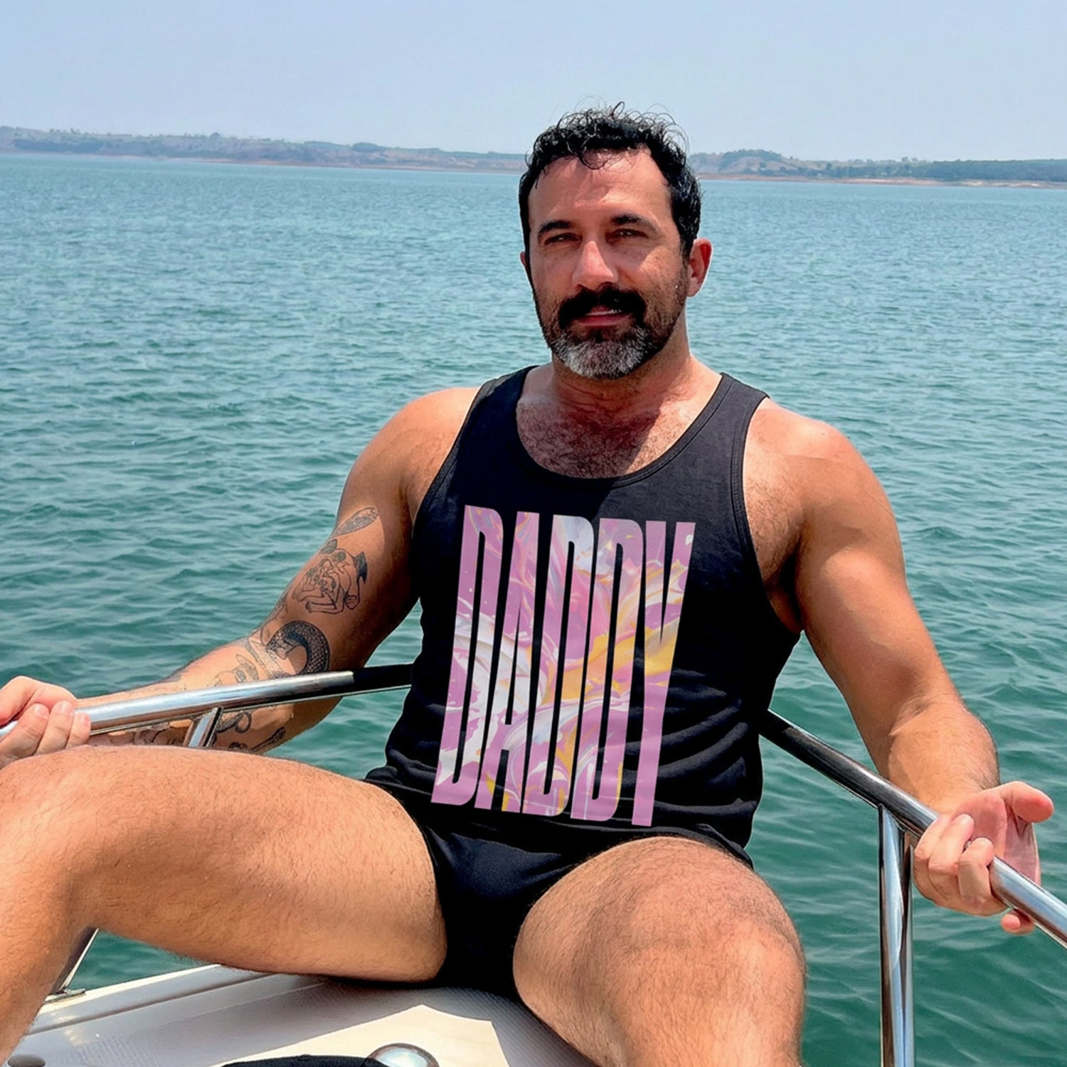 Model in black Gayer Things Daddy pride tank — marble DADDY graphic, lifestyle