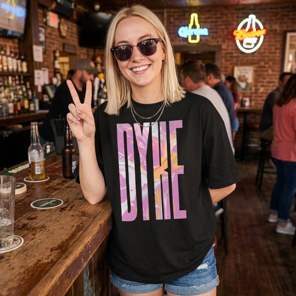 Lifestyle: model in black Gayer Things Dyke oversized tee at a bar — peace sign, neon signage, queer nightlife