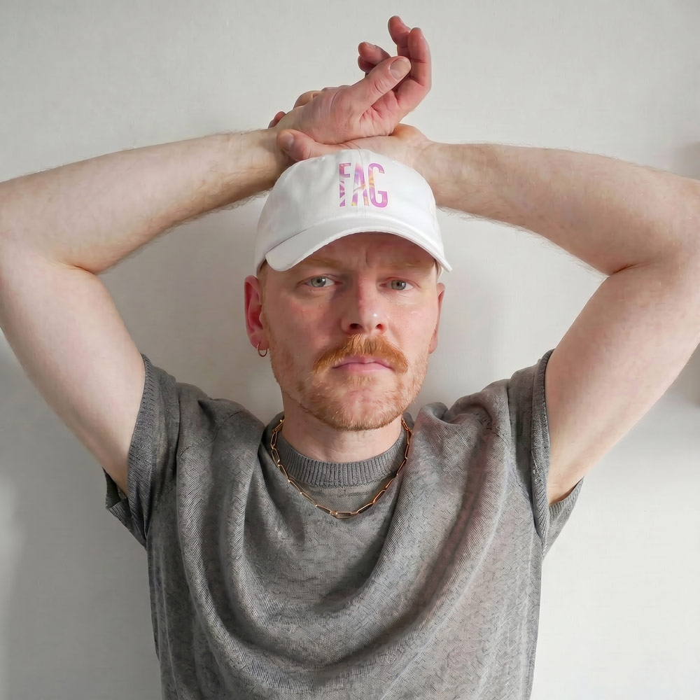 Model wearing Gayer Things LGBTQ+ pride baseball cap, side profile streetwear styling